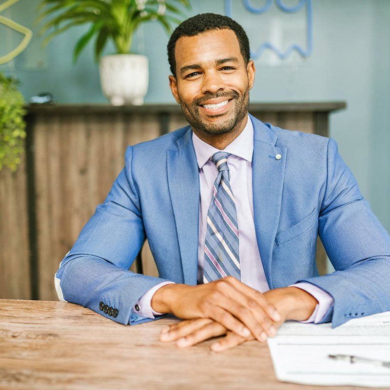Man Sitting at Table and Smiling Man Sitting at Table and Smiling
